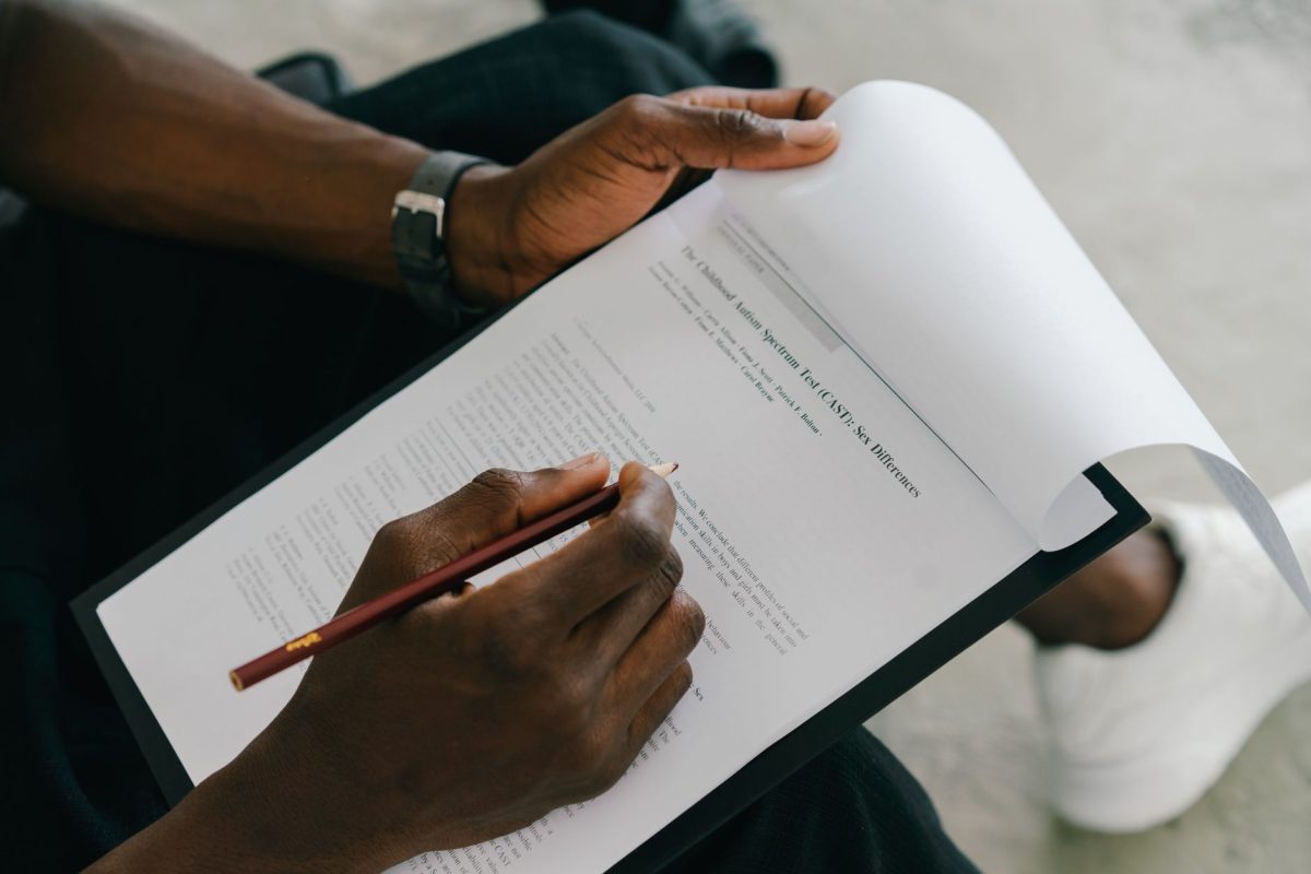 Close-up of a person filling out a paper evaluation with a pen