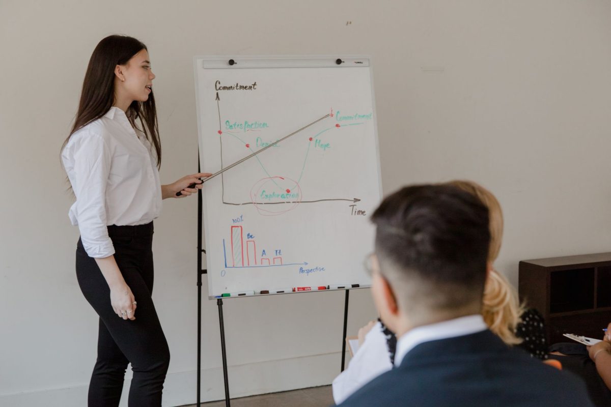 A corporate trainer writing key concepts on a flipchart during a team seminar