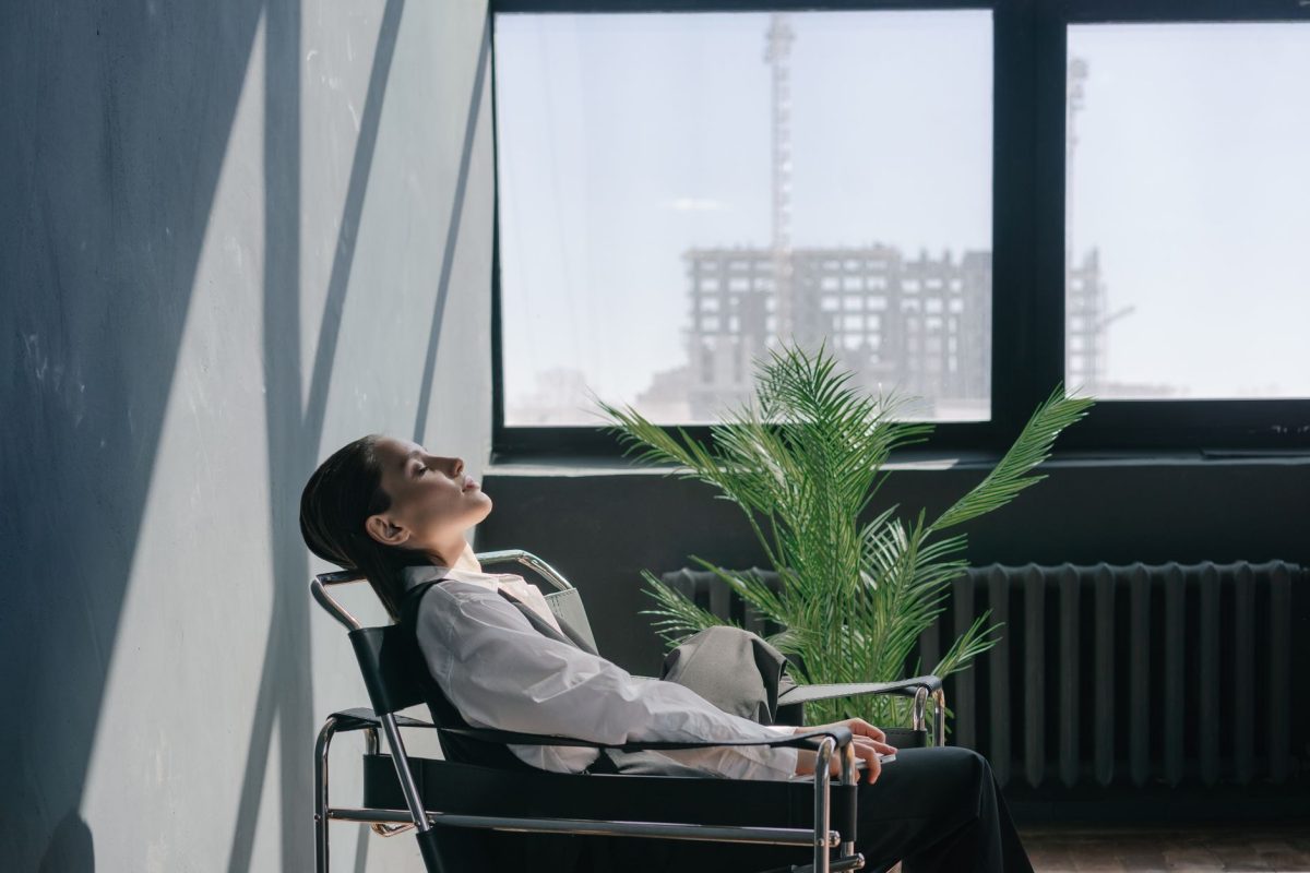 A professional pausing with eyes closed and taking a composed breath during a work meeting