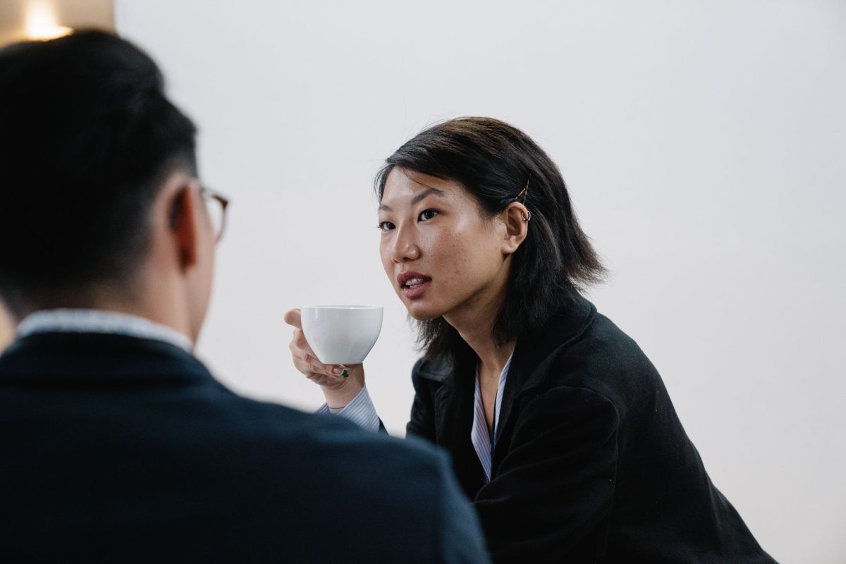 Two colleagues engaged in a focused, empathetic one-on-one conversation across a meeting table