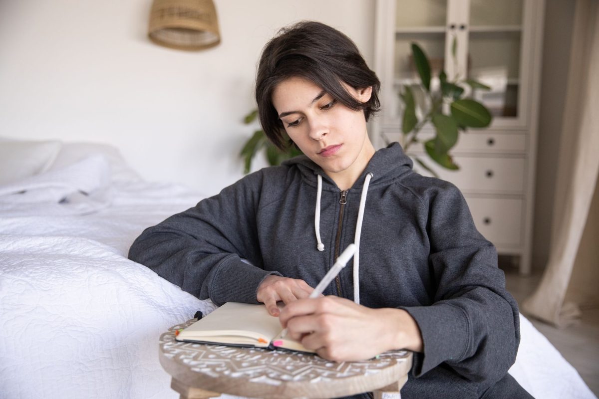 A professional writing in a notebook at a quiet desk for self-reflection and emotional debriefing