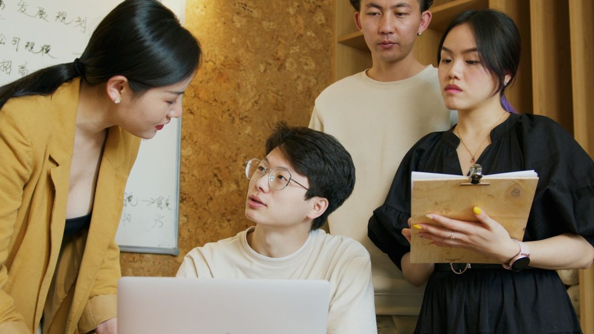 Two coworkers reviewing work on a laptop with supportive and open body language