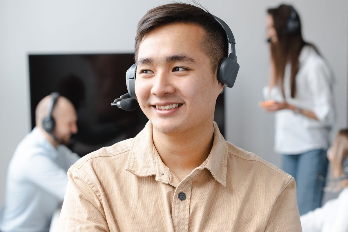 Nhân viên hỗ trợ khách hàng đeo tai nghe mỉm cười thân thiện