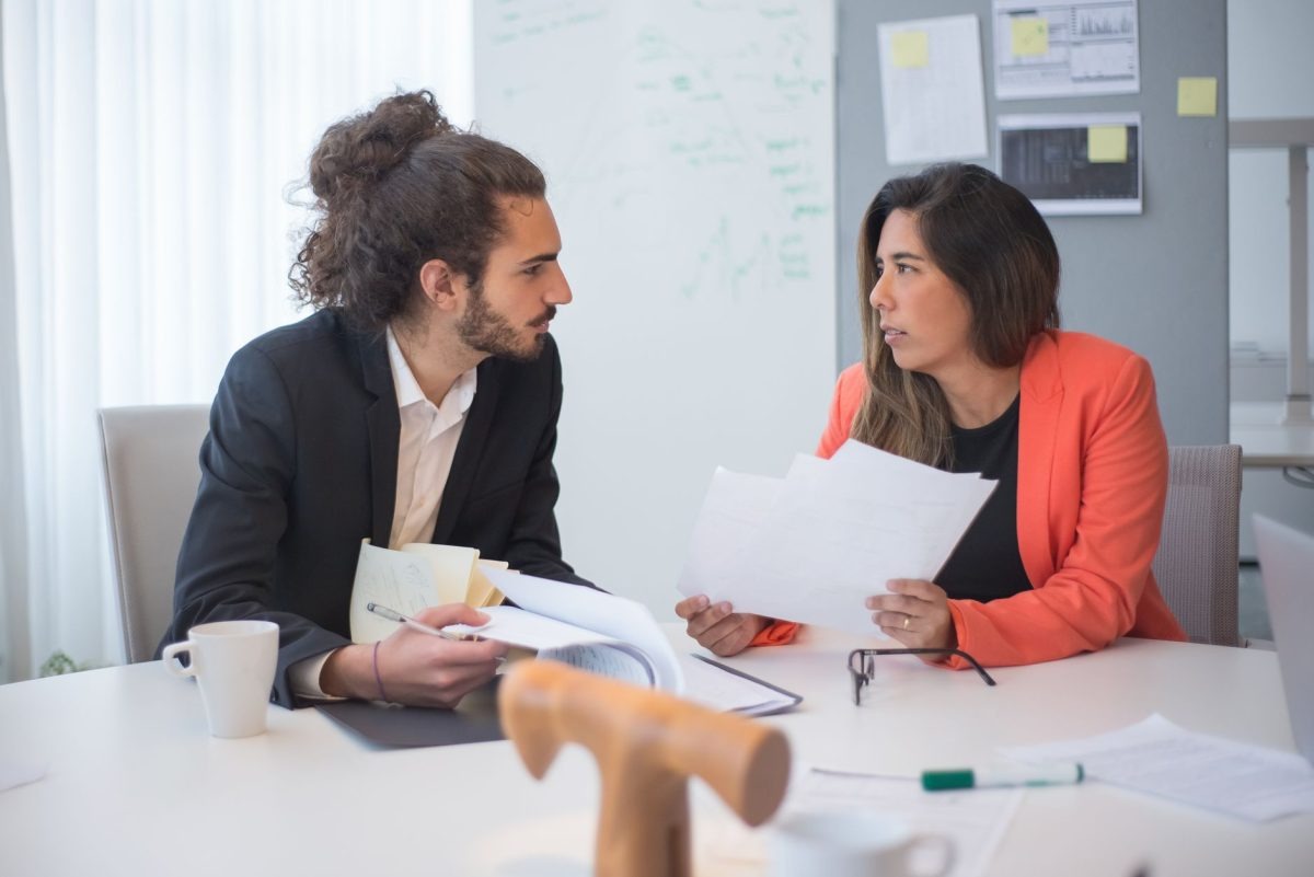 Two business professionals sitting opposite each other and listening attentively during a conversation