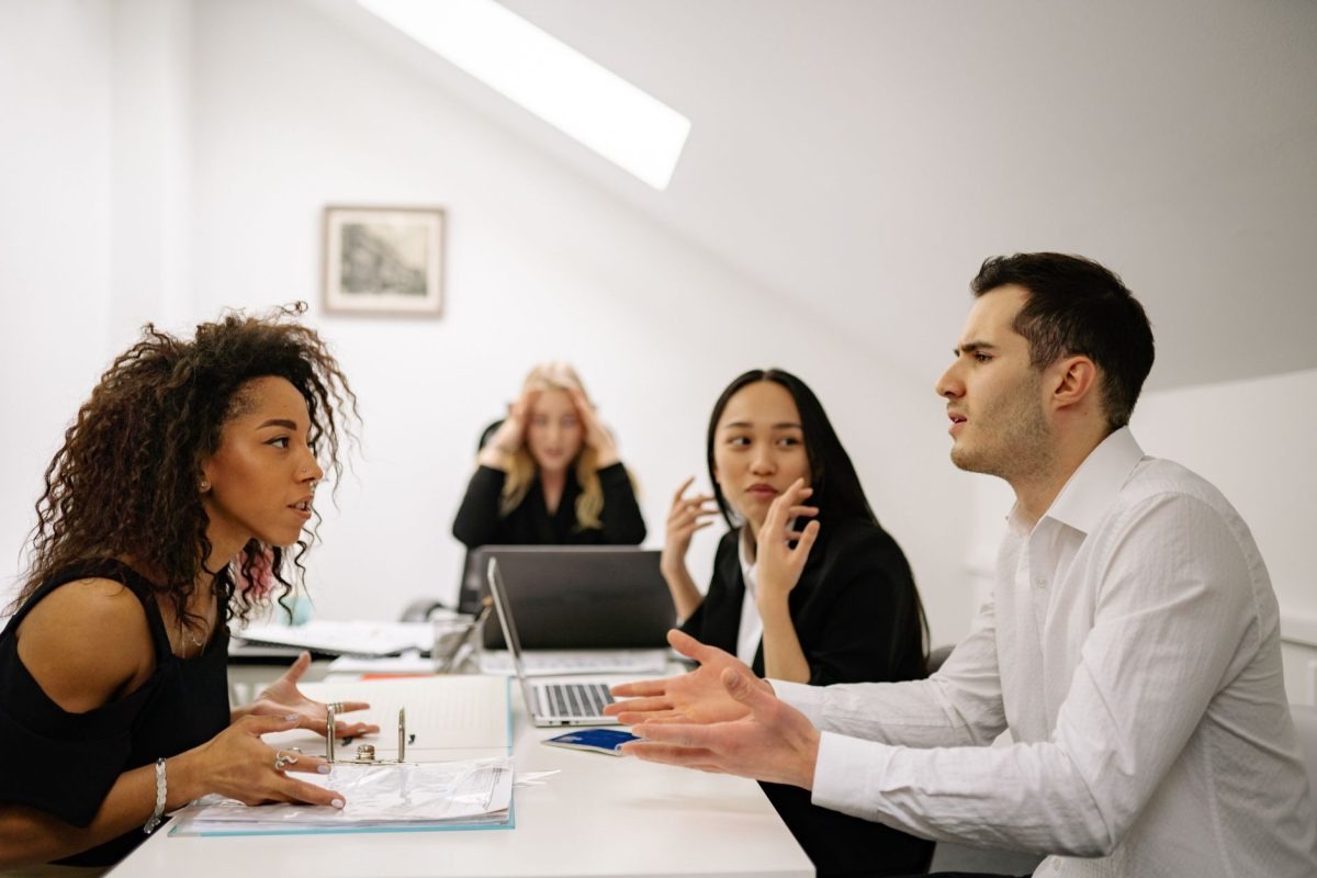 Two coworkers calmly discussing a project to resolve a workplace disagreement together