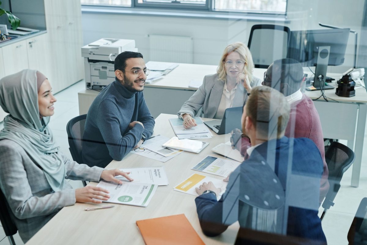 A group of professional colleagues collaborating and sharing feedback in a modern meeting room