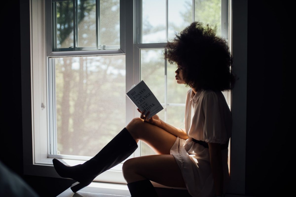 A woman quietly reading a book in a peaceful room filled with natural light