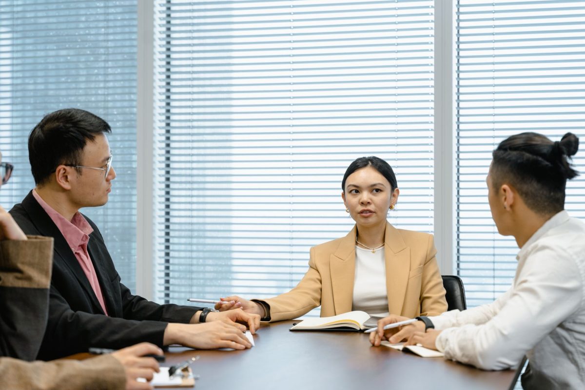 A group of professionals having a focused discussion in a modern office meeting room.