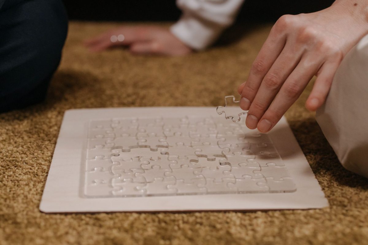 Close-up of hands holding a digital tablet displaying abstract geometric patterns and logic puzzle shapes