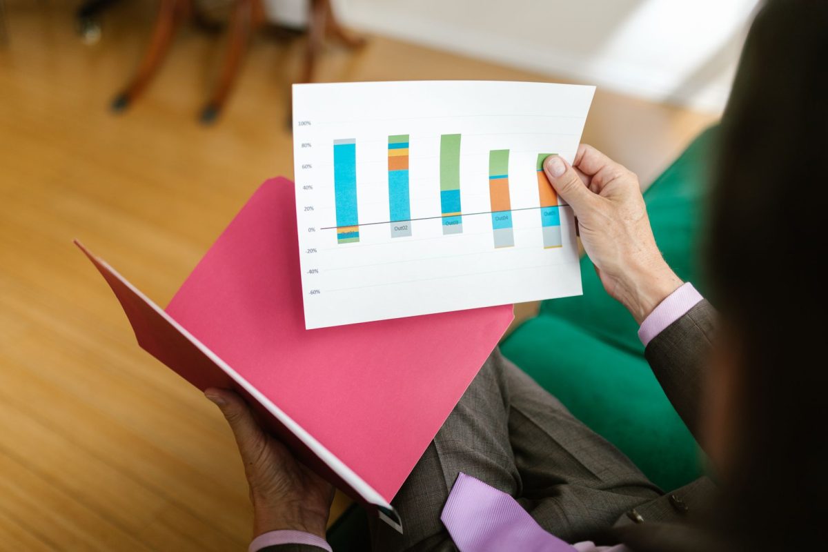 A professional examining documented research papers with statistical bell curves and confidence interval charts