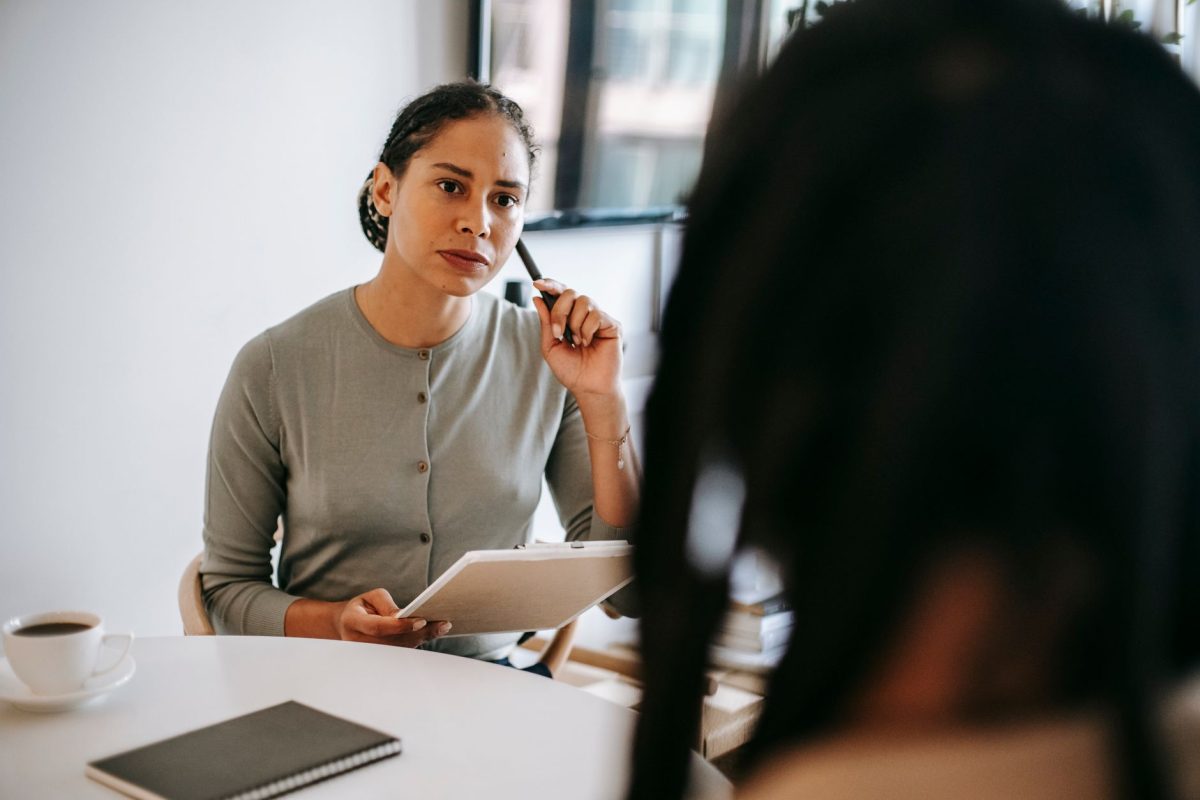 A licensed clinical psychologist administering a formal cognitive evaluation to a client across a desk