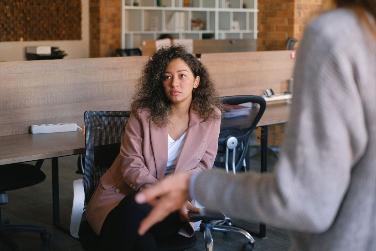 Two people engaged in calm, attentive discussion in a bright modern office