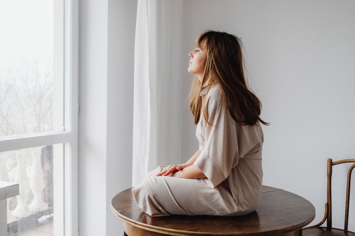 A person pausing by a window to reflect thoughtfully before taking action
