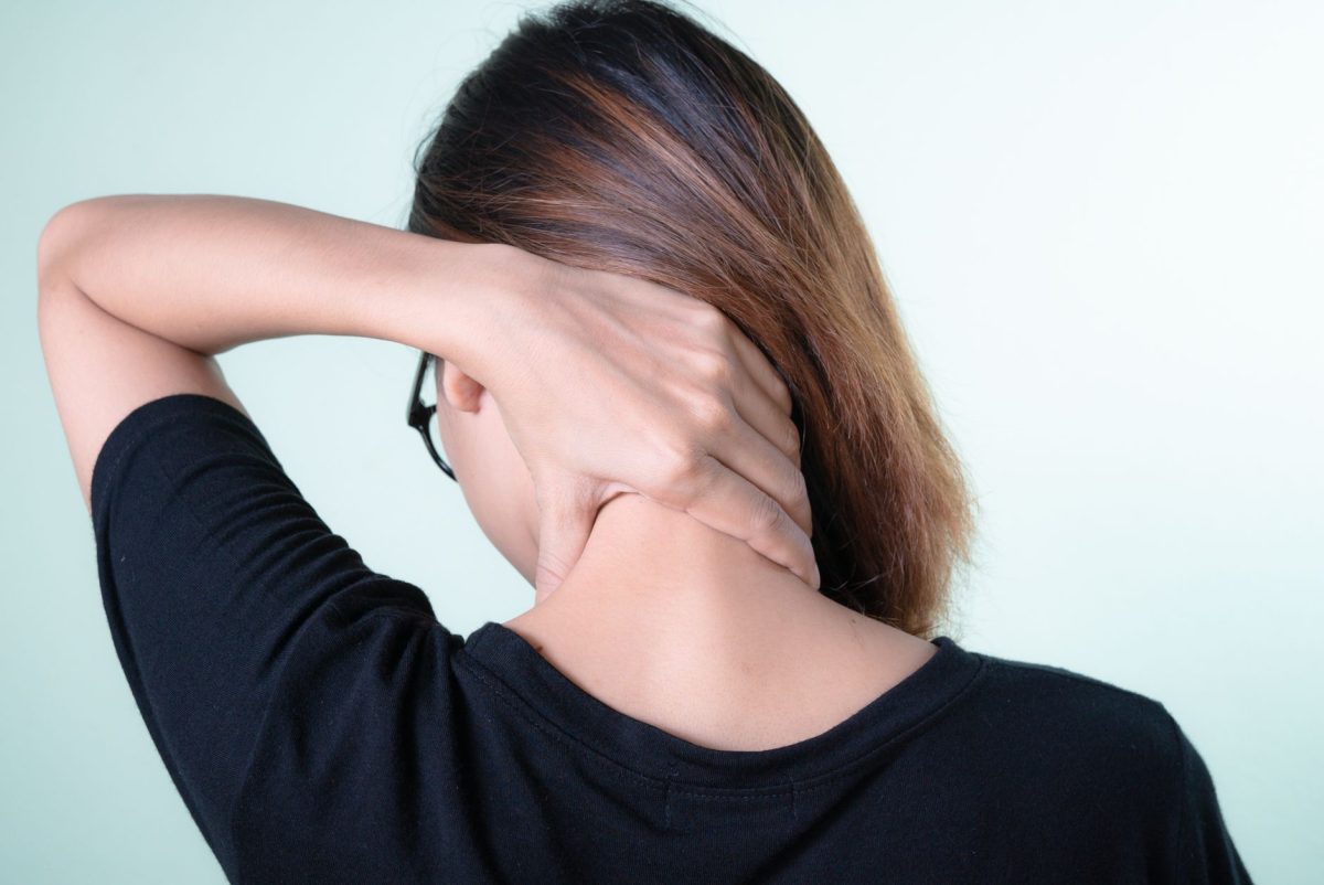 A professional touching their neck while noticing physical bodily cues during work