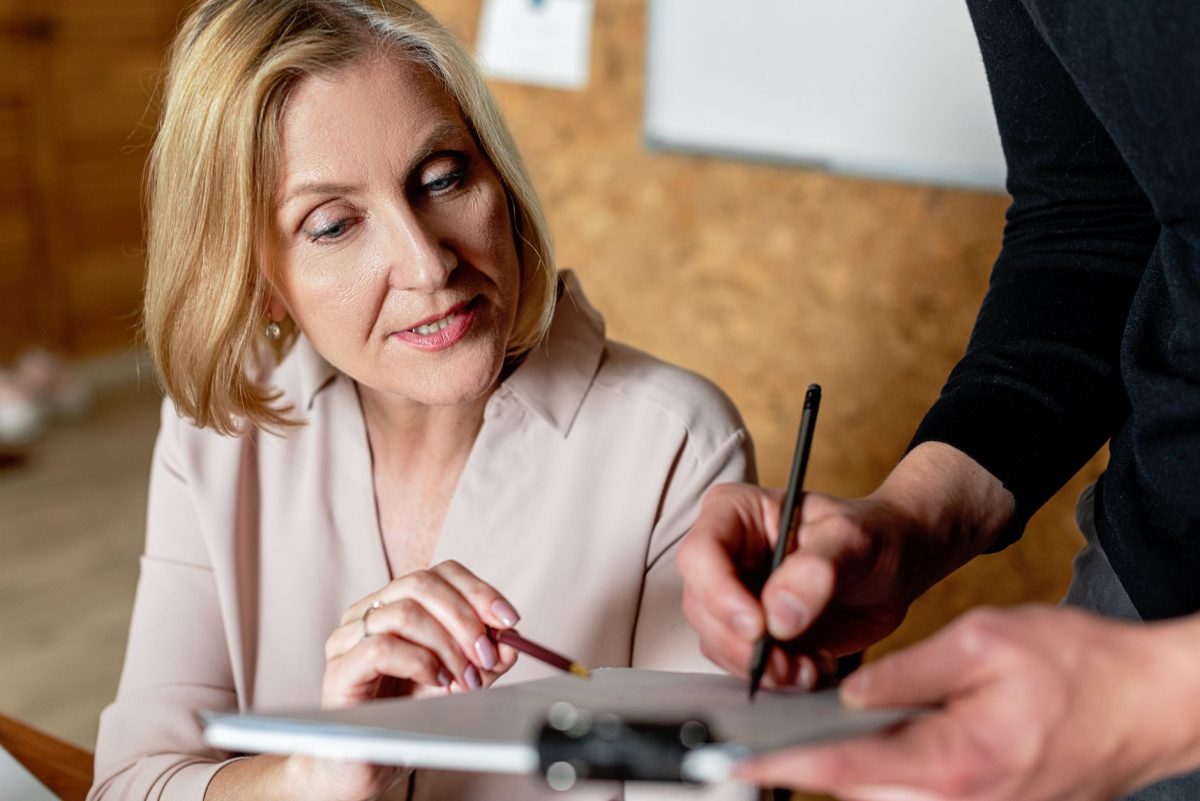 A mentor and colleague reviewing written feedback together across a conference table